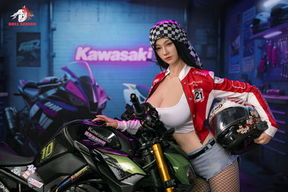 Realistic female doll in red racing jacket, checkered bandana, holding helmet beside Kawasaki motorcycle in garage