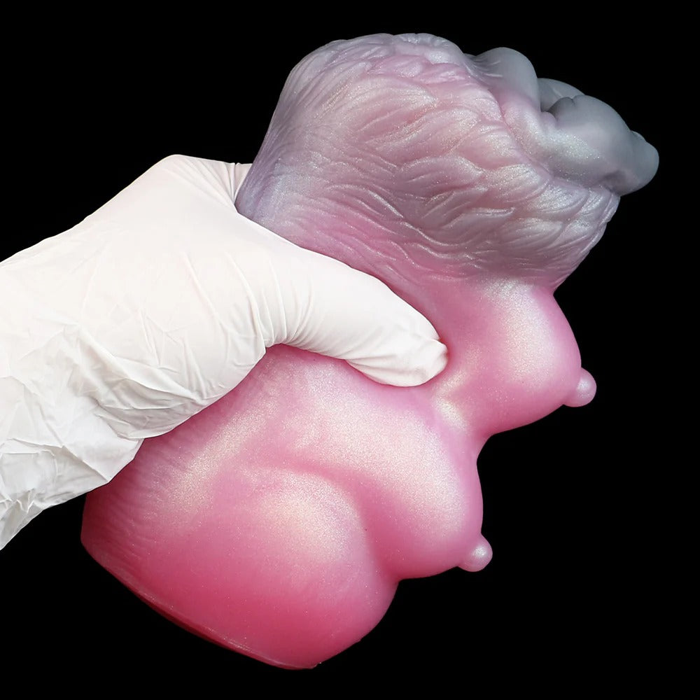 Pink realistic male masturbator with detailed labia and textured surface, held in gloved hand against black background