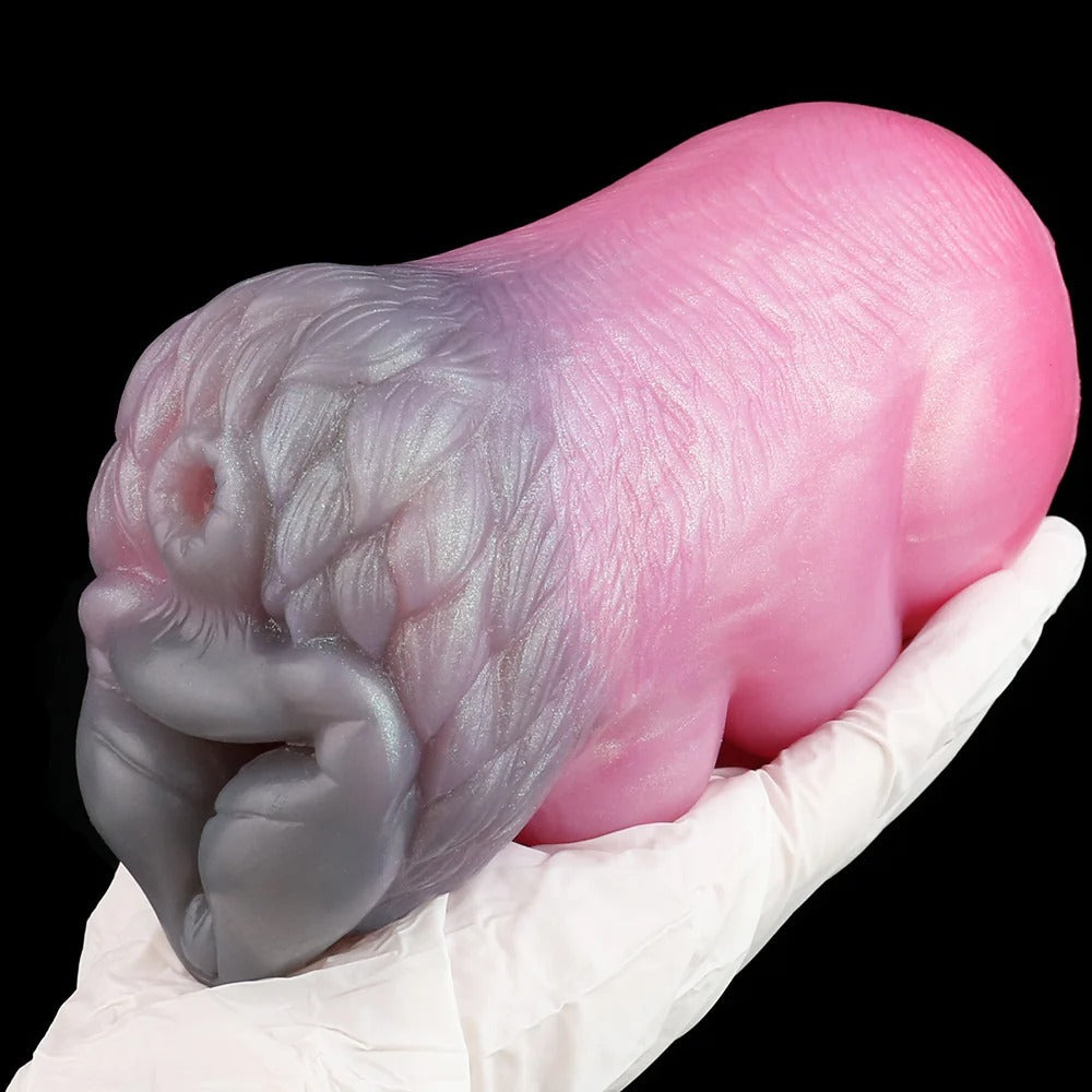 Realistic pink and gray silicone male masturbator with detailed vaginal texture, held in gloved hand