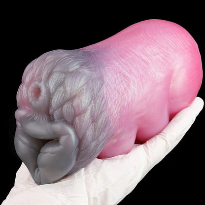 Realistic pink and gray silicone male masturbator with detailed vaginal texture, held in gloved hand