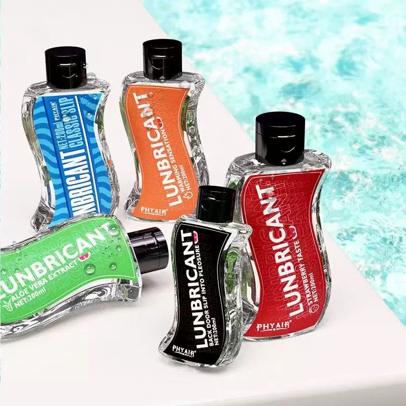 Five PHYAIR Lunbricant bottles with colorful labels—blue, orange, green, black, red—showing varied textures and flavors like aloe vera and strawberry, set beside pool water.