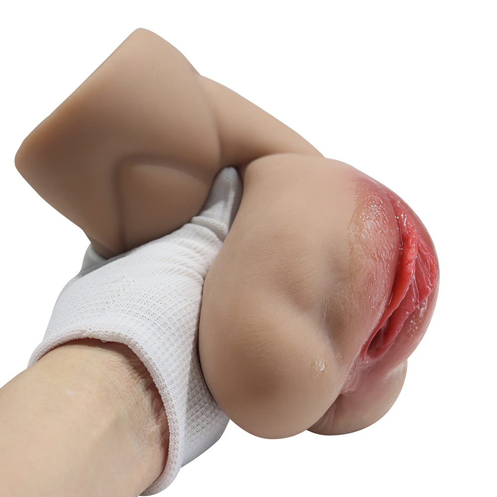Realistic flesh-toned male masturbator with detailed labia, smooth skin texture, and natural pink inner lining held in gloved hand